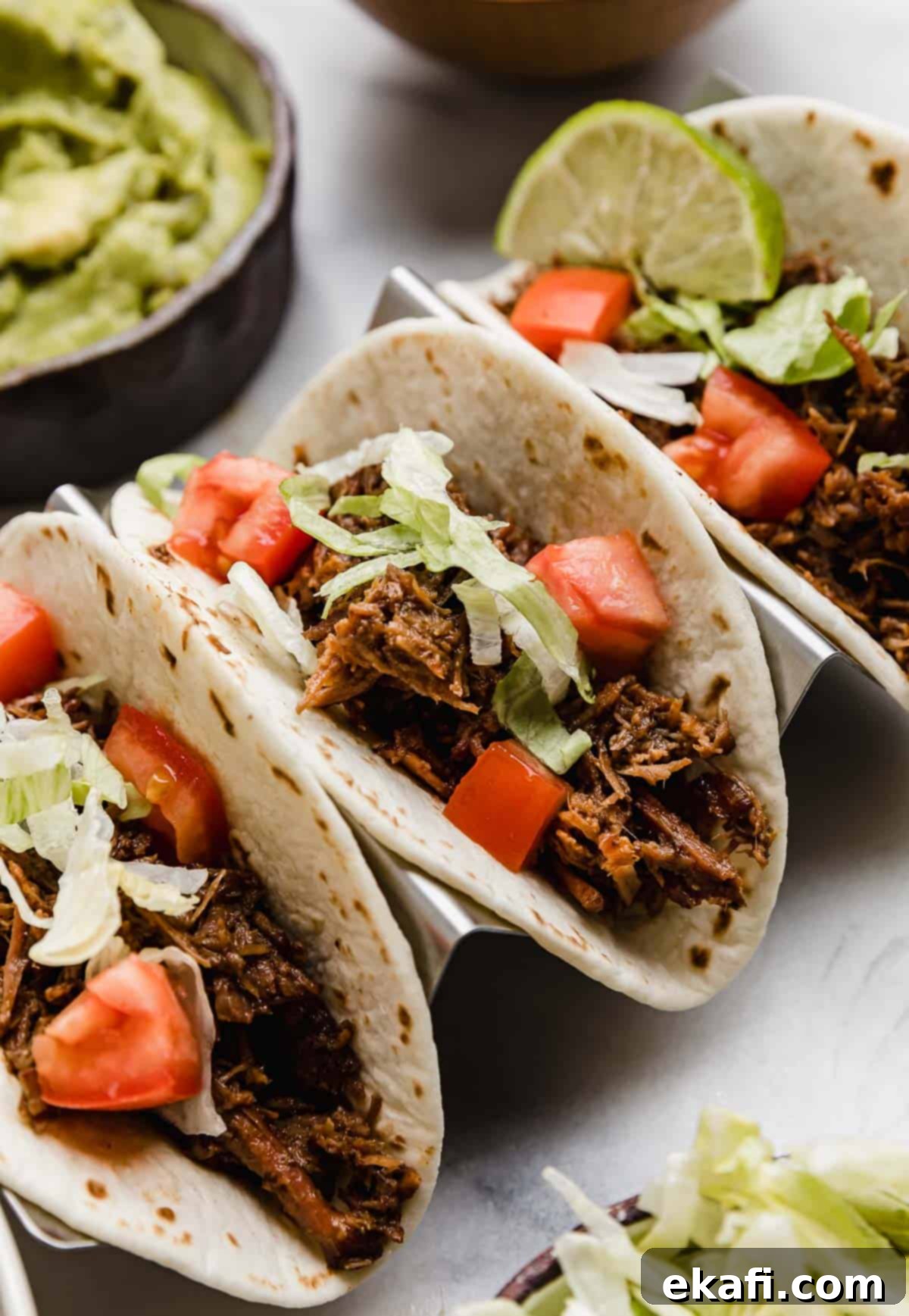Fall-Apart Tender Slow Cooker Beef Tacos 6 Three shredded beef tacos (made in the crock pot) topped with lettuce, tomato and guacamole.