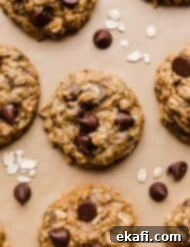 Cozy Pumpkin Chocolate Chip Oatmeal Delights 8 Oatmeal chocolate chip Pumpkin Cookies topped with semi-sweet morsels on a Kraft parchment paper.