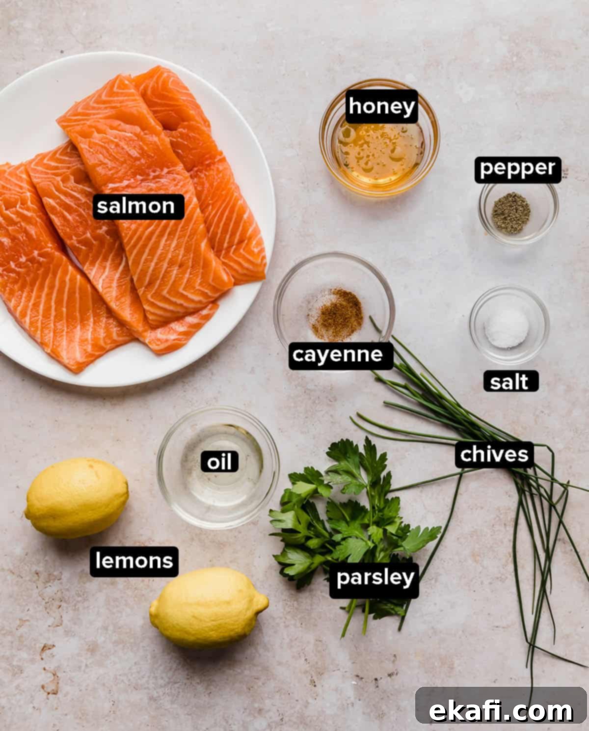 Sweet and Zesty Glazed Salmon 2 Lemon Honey Glazed Salmon ingredients laid out on a textured tan background, including salmon fillets, honey, lemon, fresh herbs, and spices.