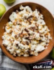 Creamy Snickers Apple Delight 8 Overhead photo of a salad with snickers and apples in a brown bowl topped with caramel to make the best Apple Snickers Salad recipe.