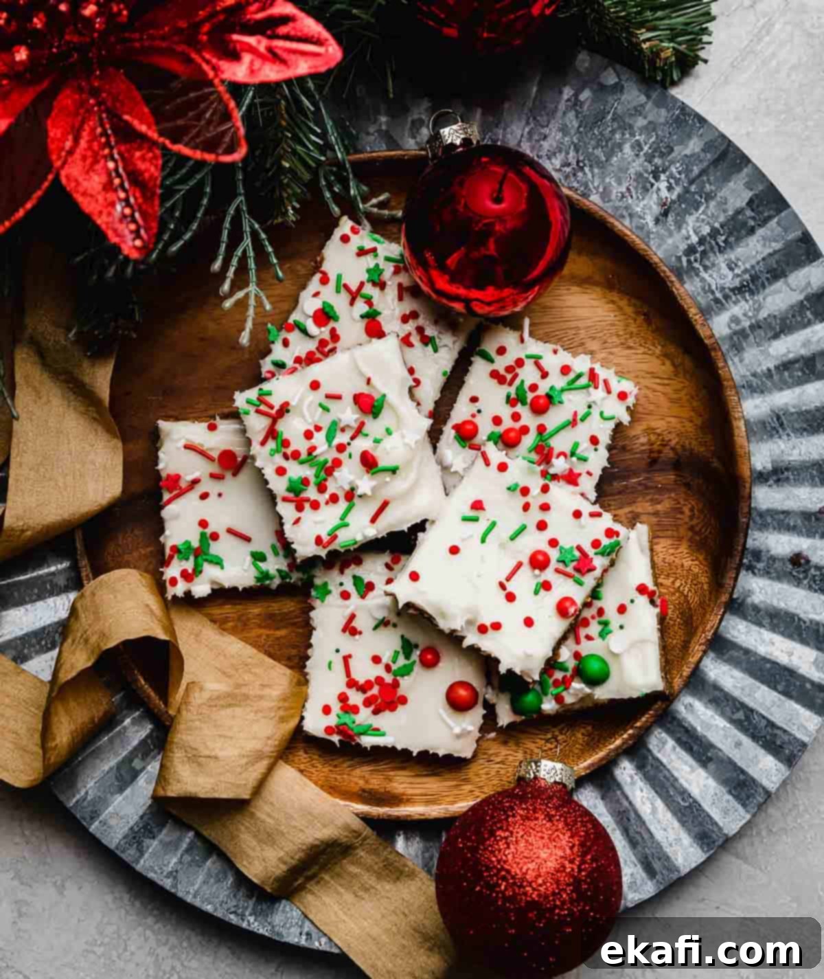 Soft & Chewy Gingerbread Bars 7 Gingerbread Cookie Bars cut into squares, topped with cream cheese frosting and Christmas sprinkles on a brown plate.