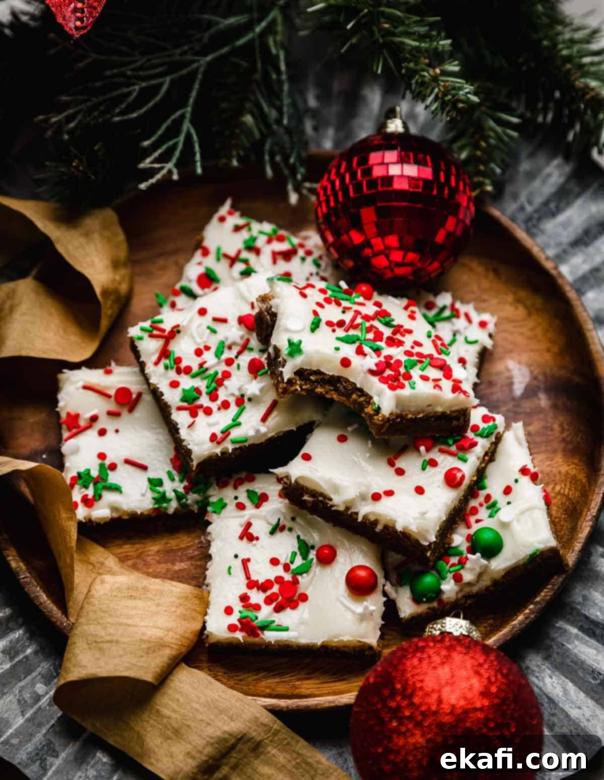 Soft & Chewy Gingerbread Bars 8 A bite taken out of a frosted Gingerbread Cookie Bar on a brown plate.