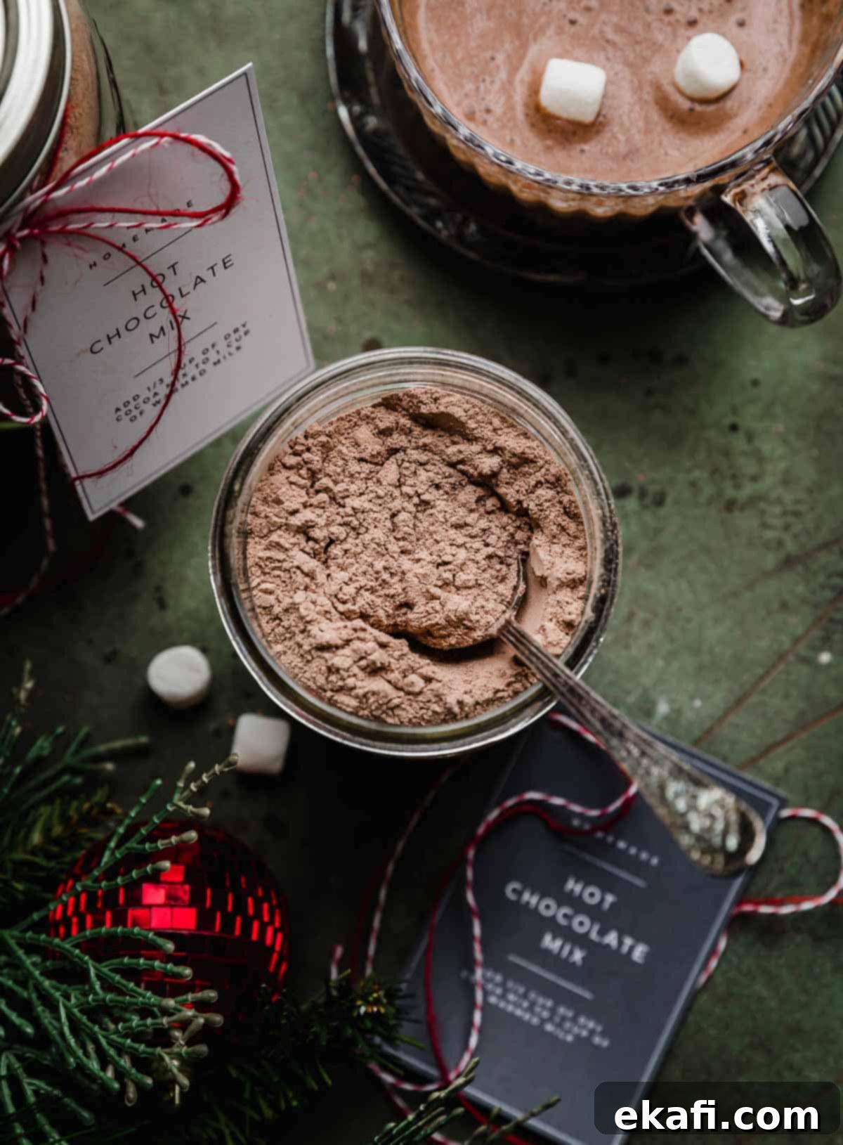 Homemade Hot Chocolate Delight 2 Overhead photo of Homemade Hot Cocoa Mix in a glass mason jar on a dark forest green background.