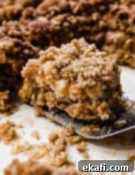 Golden Caramel Chews 8 A square Caramelita on a metal spatula, perfectly layered with oats, white chocolate, and caramel.