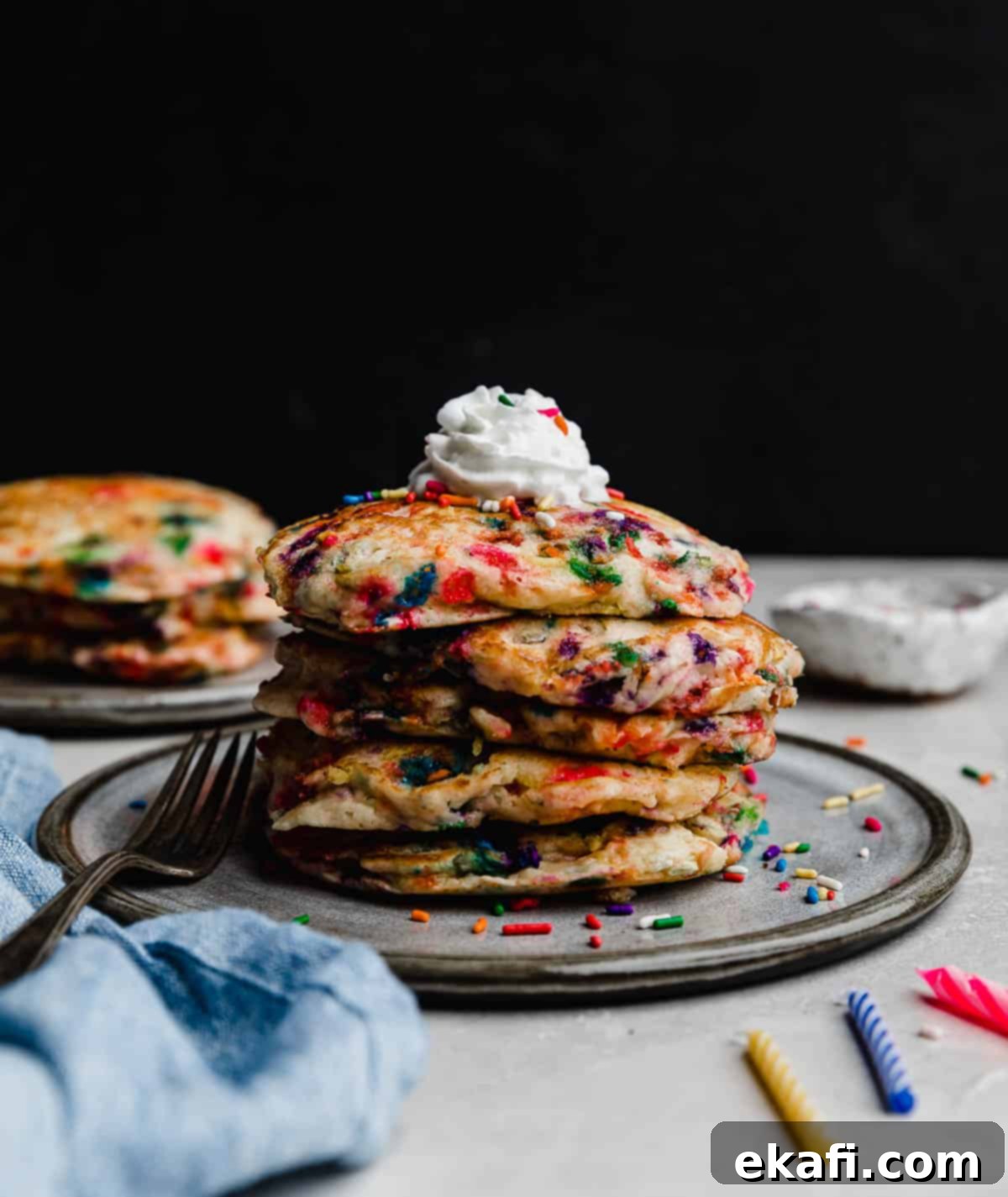 Confetti Morning Cakes 2 A stack of Birthday Cake Pancakes (funfetti pancakes) on a gray plate against a black background.
