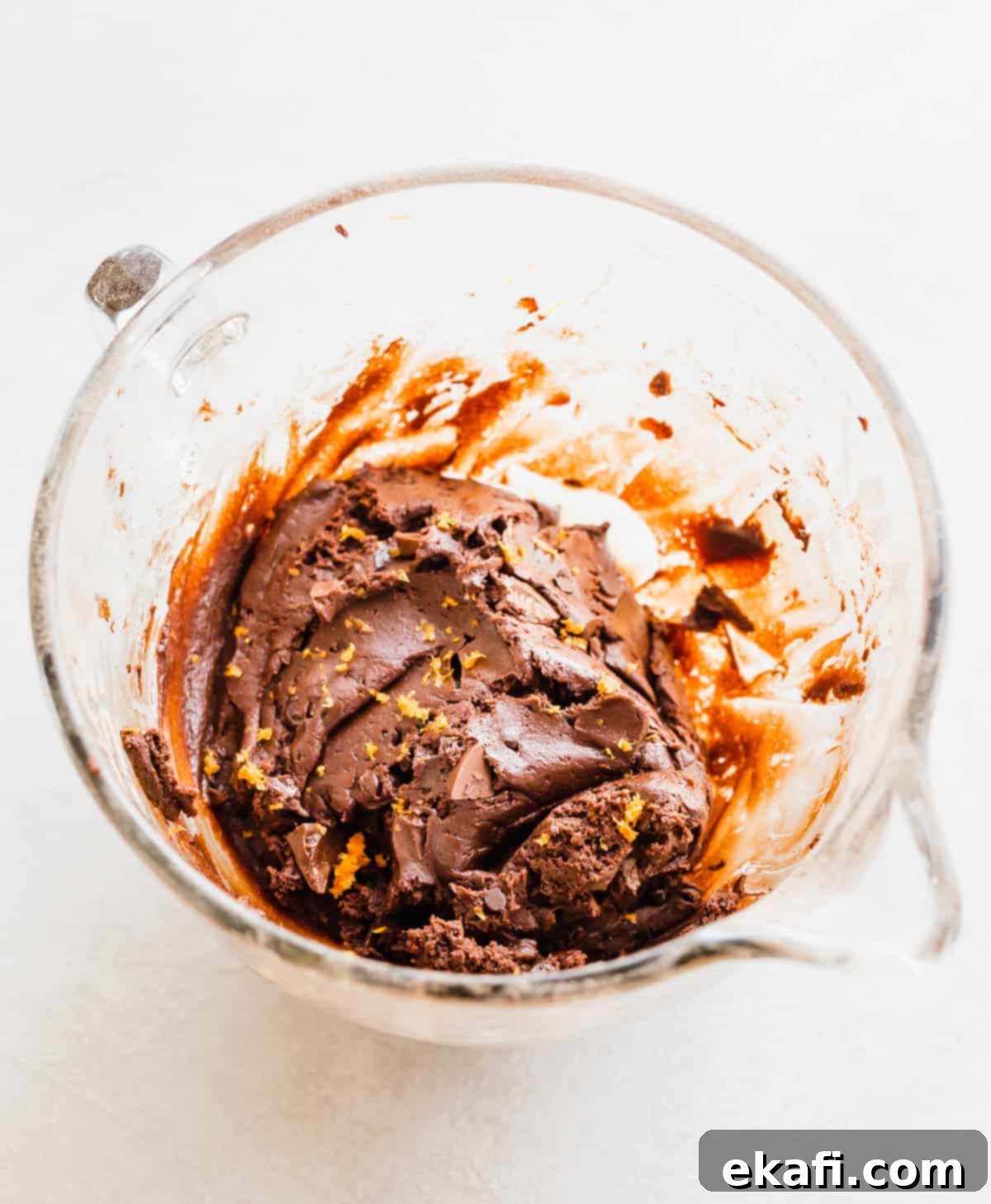 Irresistible Chocolate Orange Cookies 5 Chocolate Orange Cookie dough made with cream cheese and fresh orange zest in a glass mixing bowl on a white background.
