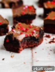 Crimson Oreo Truffle Dream Bars 9 A chocolate covered red velvet brownie topped with Oreo truffle with a bite taken out of the Valentines inspired brownie.