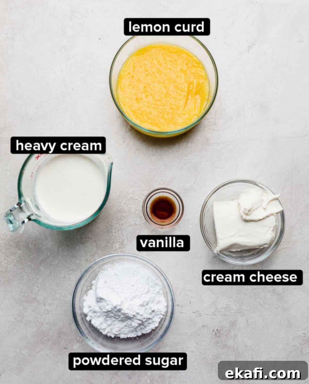 Sunshine Lemon Poppy Seed Cloud Cake 4 Ingredients used to make a whipped cream cheese frosting with lemon curd on a light gray surface: heavy cream, powdered sugar, cream cheese, vanilla, and lemon curd.