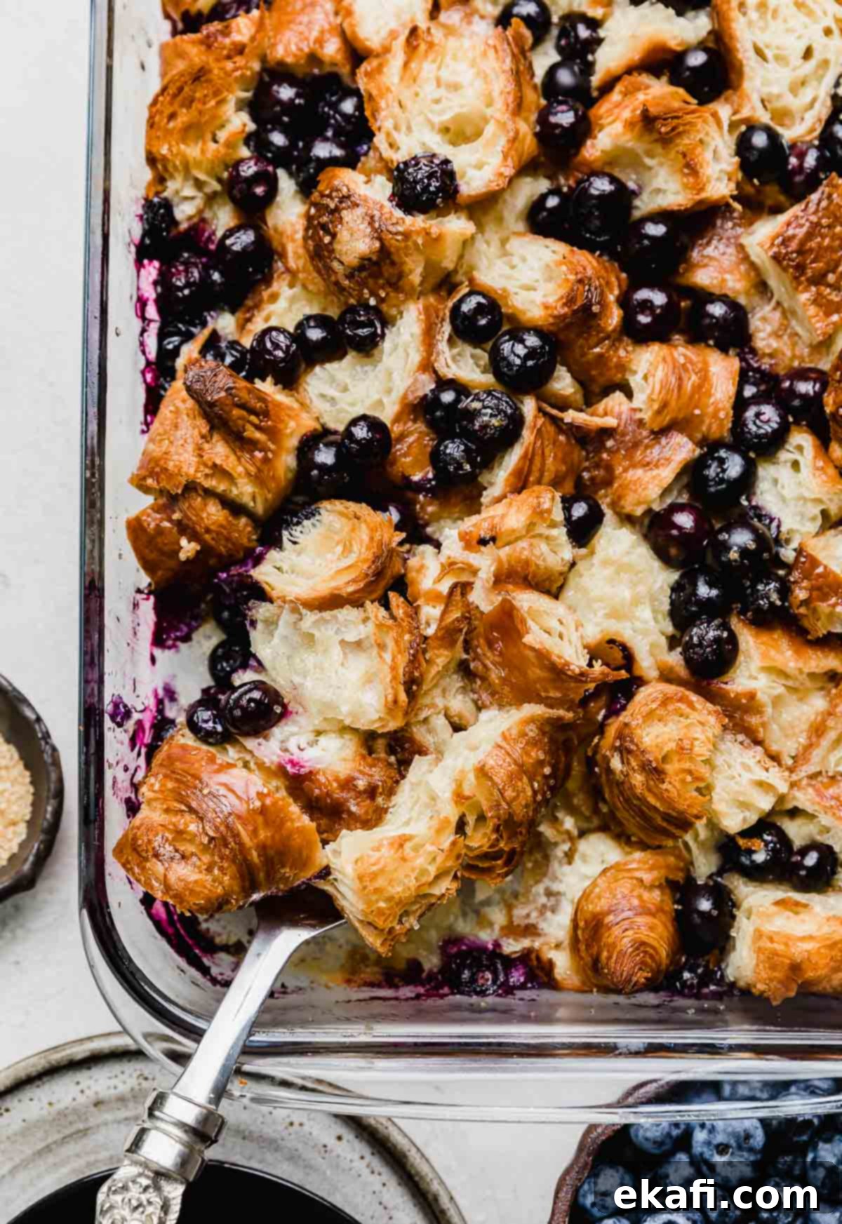 Ψητό Πρωινό με Κρουασάν και Μύρτιλα 2 Πρωινό bake με κρουασάν και μύρτιλα σε γυάλινο ταψί σε λευκή επιφάνεια, φωτογραφία από πάνω.