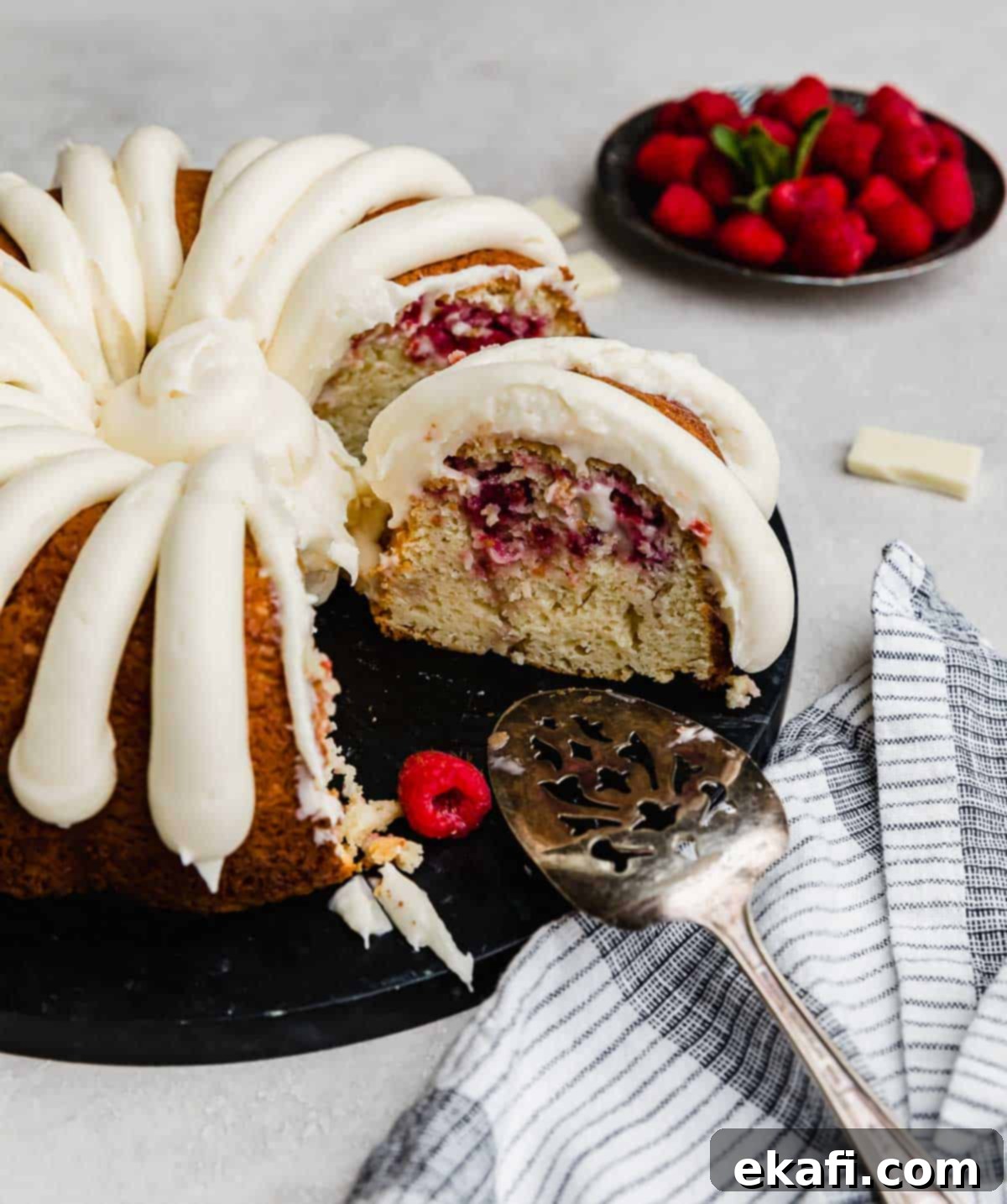 Decadent White Chocolate Raspberry Bundt Cake 8 A White Chocolate Raspberry Bundt Cake recipe with a few slices removed from the cake.