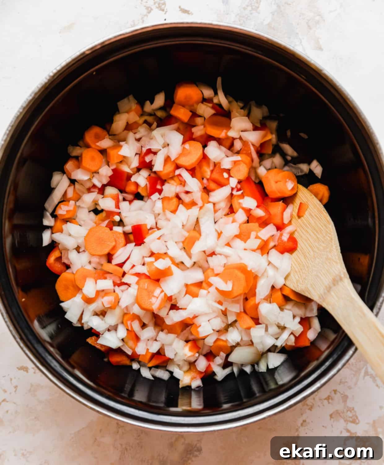The Royal Massaman Curry 4 Black pot with chopped onion, red pepper, and carrots in it.