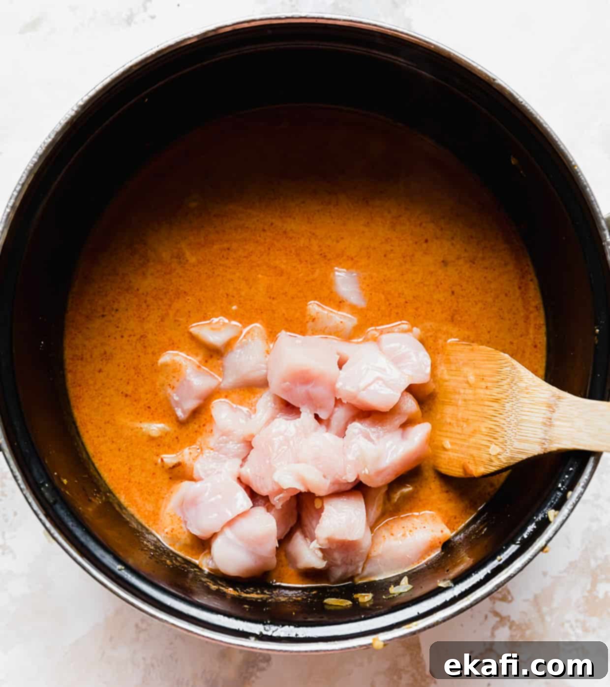The Royal Massaman Curry 7 Raw, cubed chicken in a pot with massaman curry.