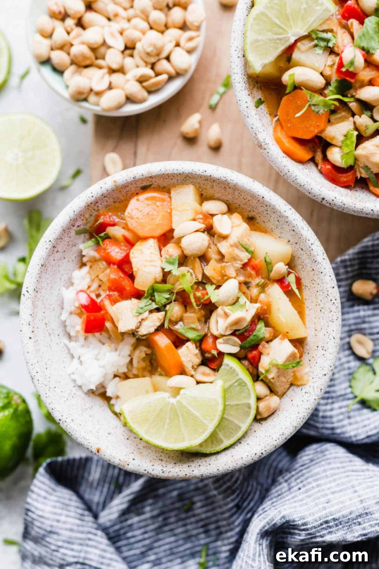 The Royal Massaman Curry 9 A bowl with Massaman Curry topped with limes, peanuts, and cilantro.