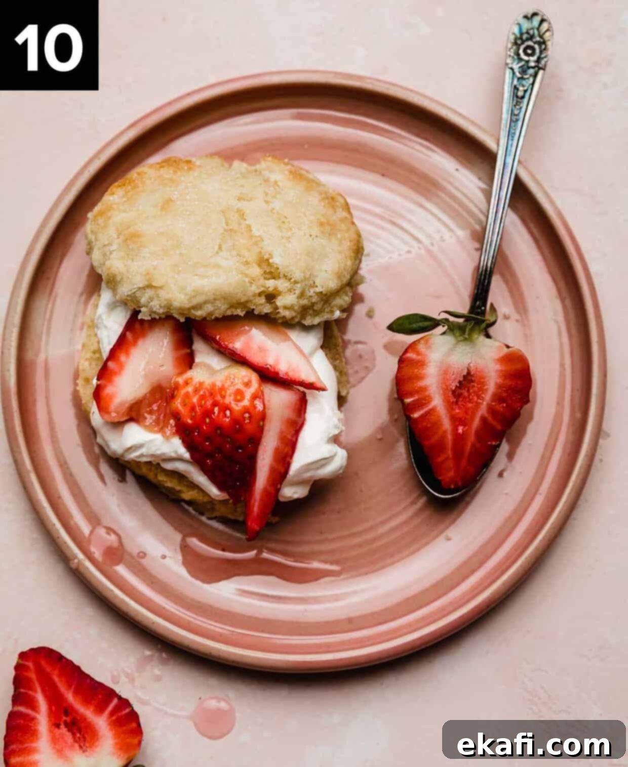 Grandma's Strawberry Shortcake 7 A classic Classic Strawberry Shortcake on a pink plate featuring a flaky biscuit topped with whipped cream and quartered strawberries.