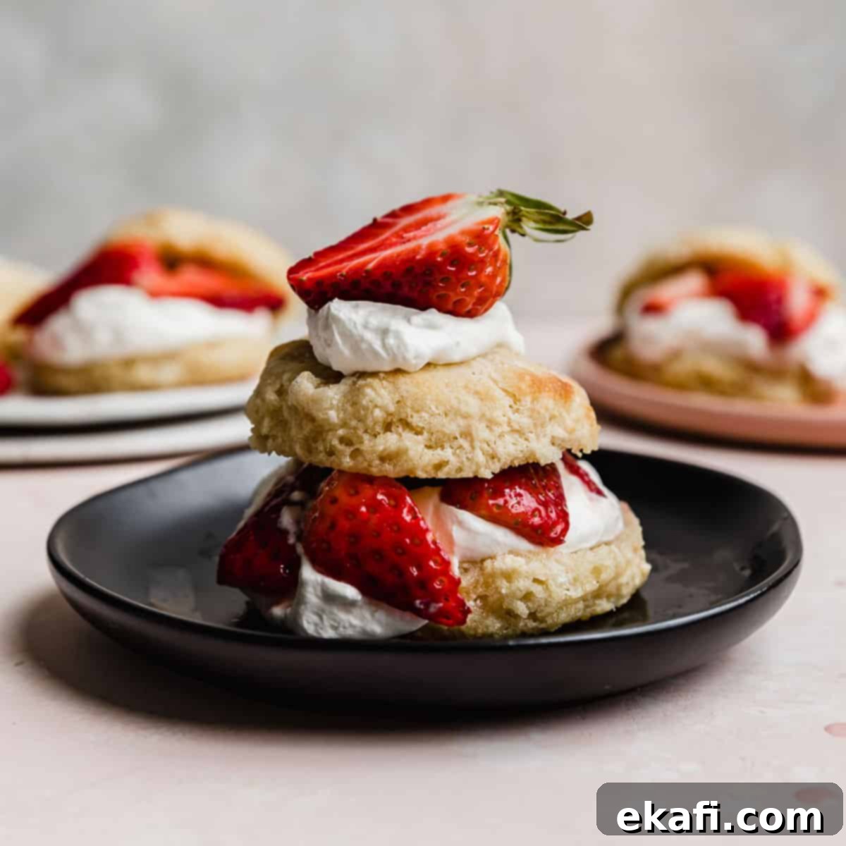 Grandma's Strawberry Shortcake 9 A classic strawberry shortcake with a flaky biscuit on a black plate.