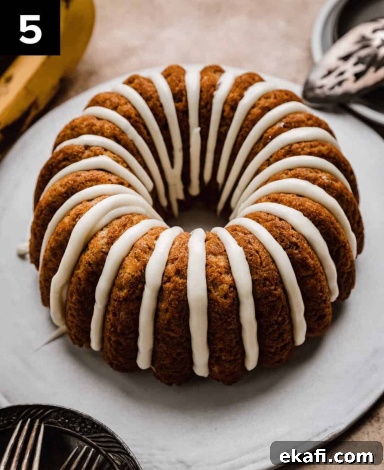 Classic Banana Bread Bundt Cake 5 A cream cheese glazed Banana Bread Bundt Cake on a white cake plate.