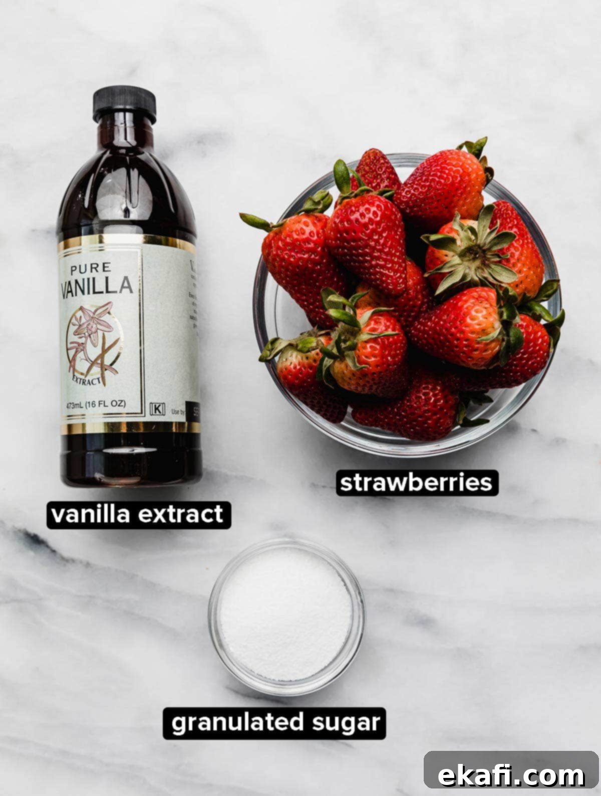 Sweet Baked Strawberries 3 Ingredients used to roast strawberries in the oven: vanilla extract, fresh strawberries, and granulated sugar on a white surface.