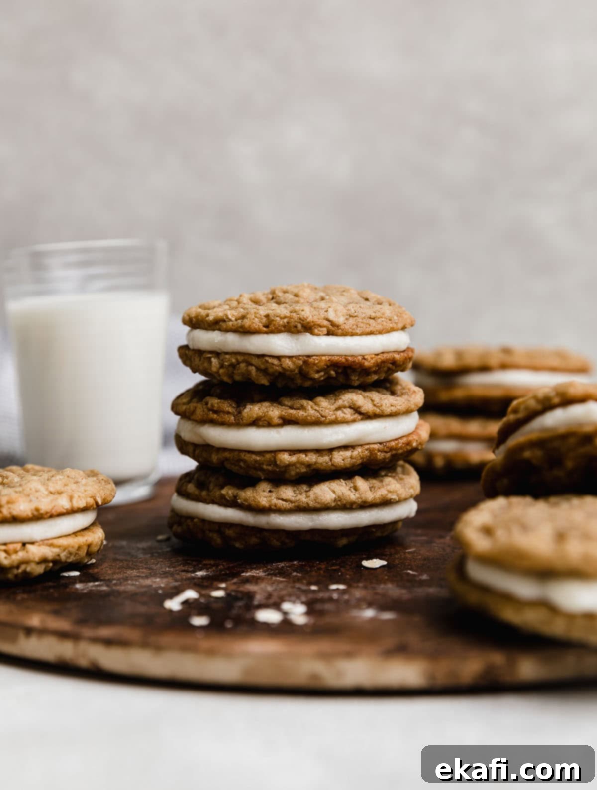 Soft Chewy Oatmeal Cream Sandwiches 2 Three oatmeal creme pies stacked on top of each other with a glass of milk in the background, showcasing the soft cookies and creamy filling.