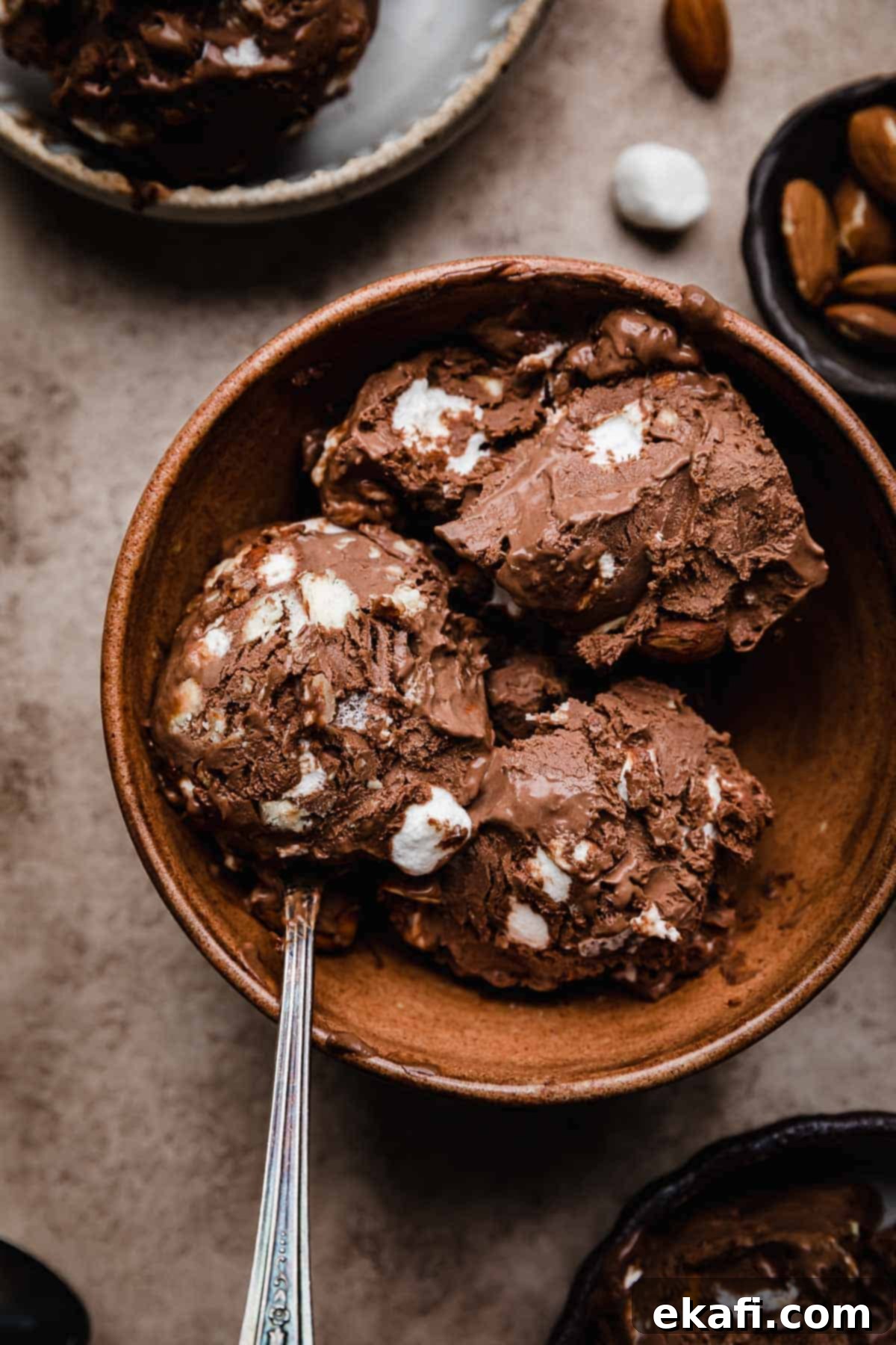 Easy Homemade Rocky Road Ice Cream 2 Rocky Road Ice Cream Recipe scooped into a brown bowl with a spoon scooping some of the marshmallow and almond chocolate ice cream.