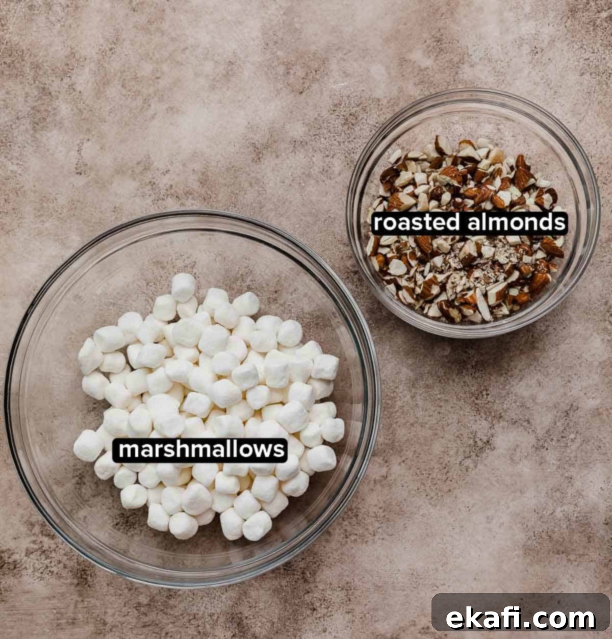 Easy Homemade Rocky Road Ice Cream 4 Rocky Road Ice Cream Recipe mix-in ingredients (mini marshmallows and toasted almonds) on a brown textured surface.
