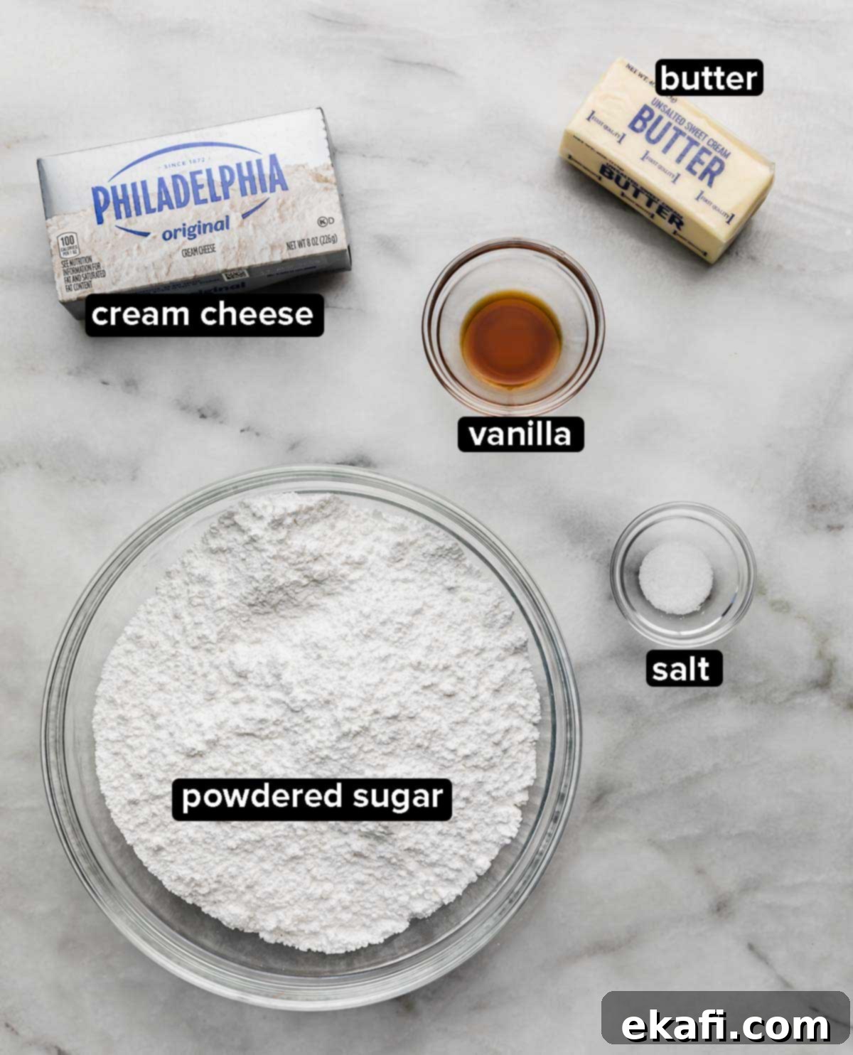 Golden Brown Butter Cream Cheese Frosting 3 Brown Butter Cream Cheese Frosting ingredients on a white and gray marble surface: powdered sugar, cream cheese, vanilla, butter, salt.