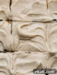 Golden Brown Butter Cream Cheese Frosting 6 Swirled Brown Butter Cream Cheese Frosting with small brown specks throughout the frosting.