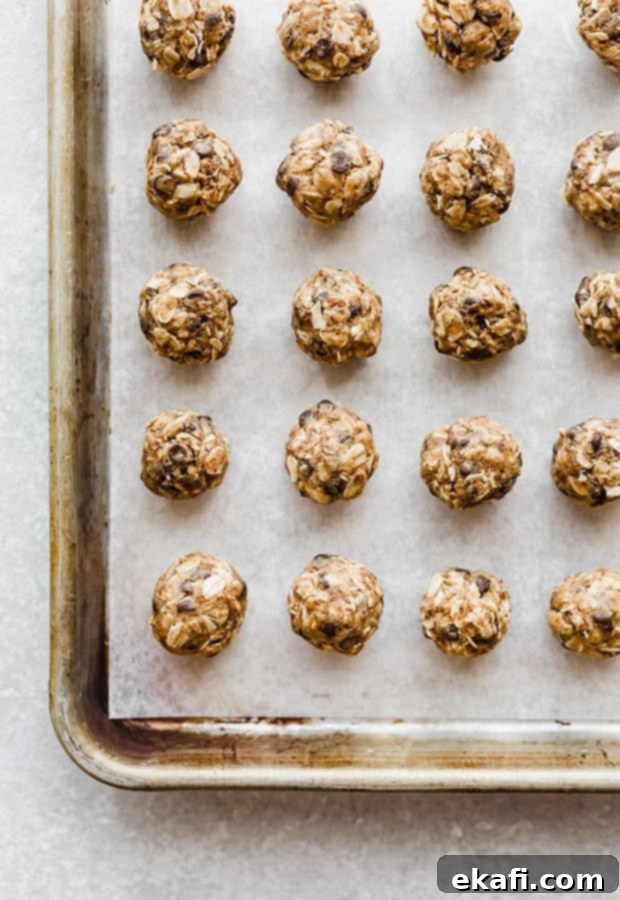 Effortless Power Bites 6 Small no-bake energy bites on a baking sheet lined with parchment paper.