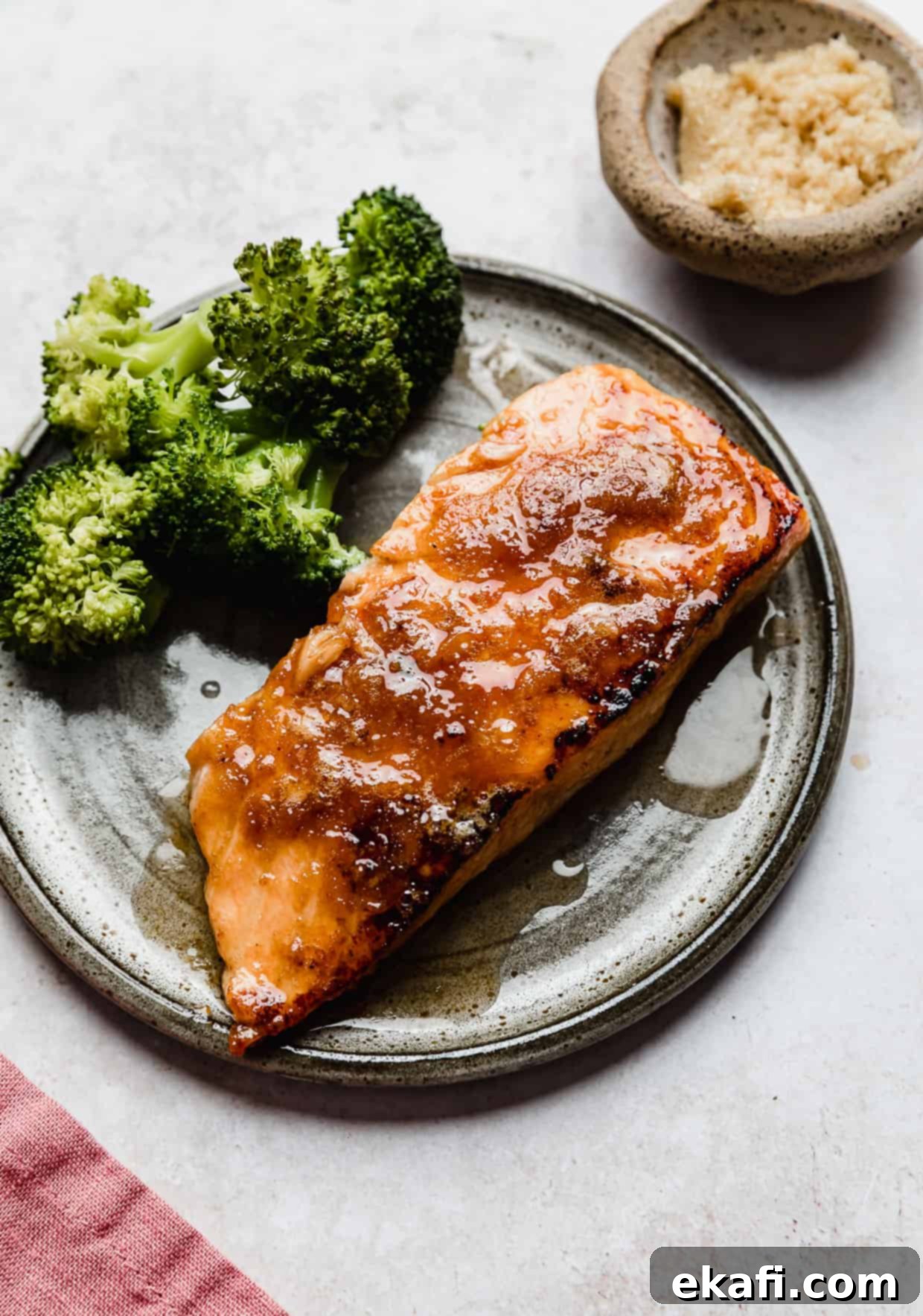 Caramelized Brown Sugar Salmon 2 Perfectly cooked Brown Sugar Crusted Salmon served with vibrant green broccoli on a sleek grey plate, highlighting its delicious crust.