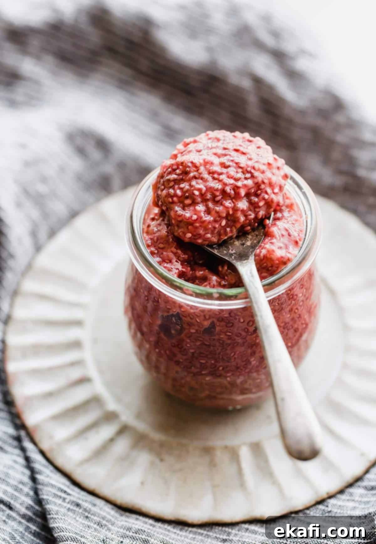 Zesty Blood Orange Chia Pudding 2 A spoon scooping out Blood Orange Chia Pudding from a glass jar.