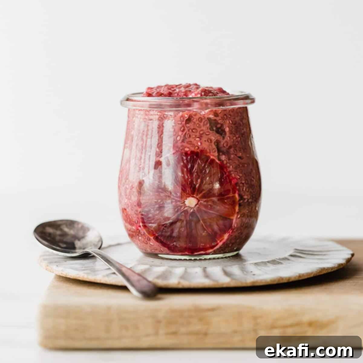 Zesty Blood Orange Chia Pudding 4 A glass jar filled with Blood Orange Chia Pudding, against a white background.