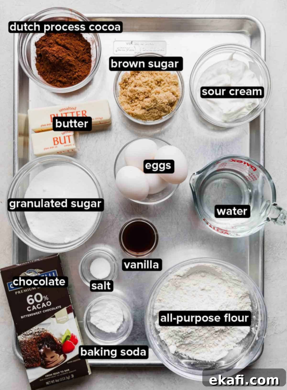 Decadent German Chocolate Creation 3 Traditional Traditional German Chocolate Cake ingredients portioned into glass bowls on a silver baking sheet.