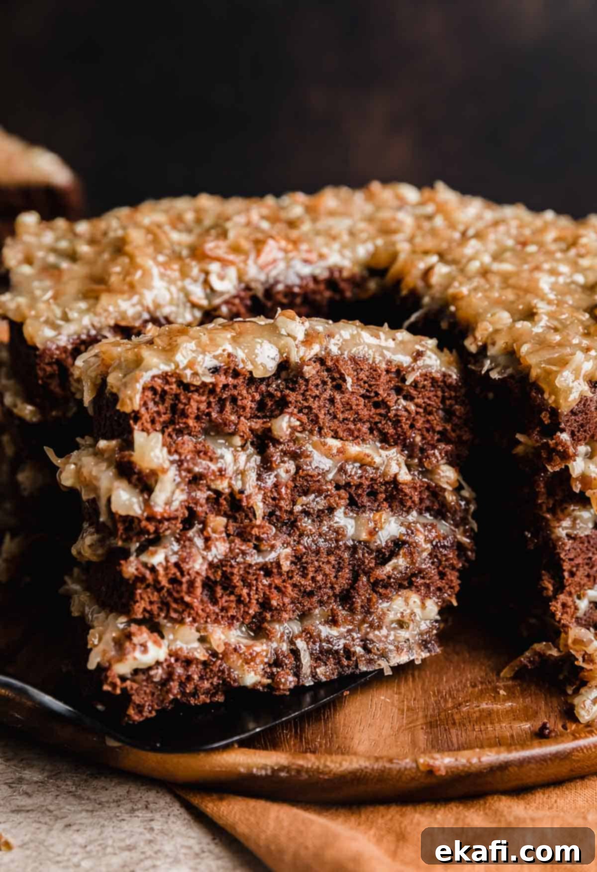 Decadent German Chocolate Creation 7 A slice of a four layer Traditional German Chocolate Cake balancing on a spatula.