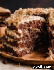 Decadent German Chocolate Creation 9 A slice of Traditional German Chocolate Cake taken from a four layer Traditional German Chocolate Cake on a wooden cake plate.