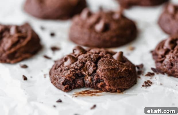 Fudgy Brownie Cookies 7 A warm, freshly baked brownie cookie with a bite taken out, revealing its soft, fudgy interior and perfectly melted chocolate chips, enticing with its deliciousness.