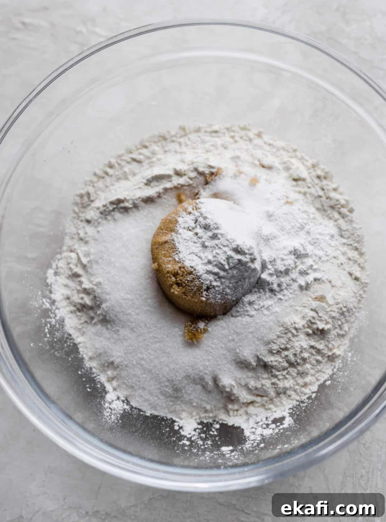 Velvet Banana Chocolate Chip Muffins 4 Flour, brown sugar, sugar and other white dry ingredients in a glass bowl.