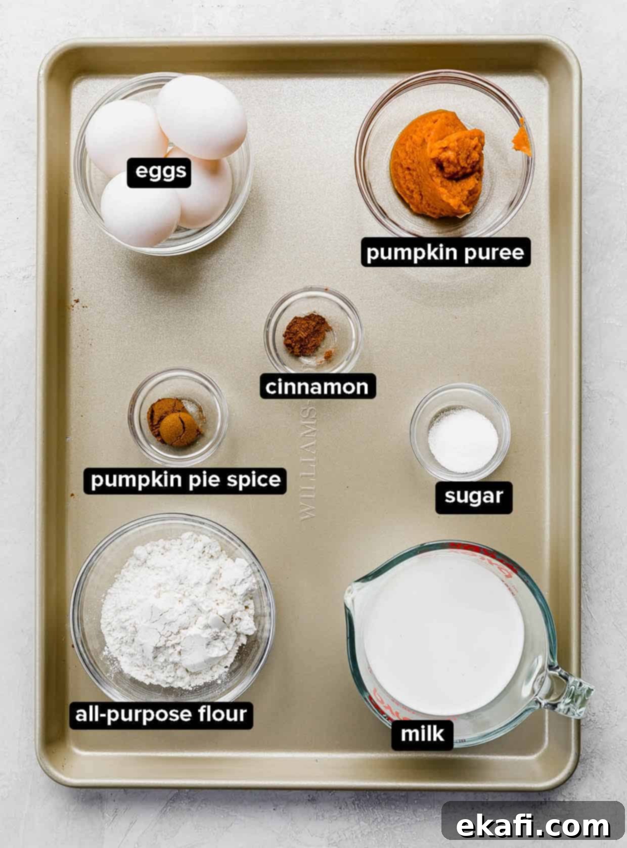 Autumn Pumpkin Crepes 3 Pumpkin Crepes ingredients portioned into glass bowls, on a gold baking sheet.
