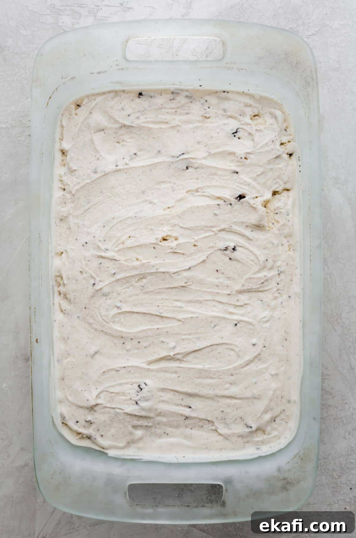 Frozen Oreo Indulgence 5 A smooth, even layer of cookies and cream ice cream spread over the Oreo crust in a rectangular baking dish, chilling in the freezer.