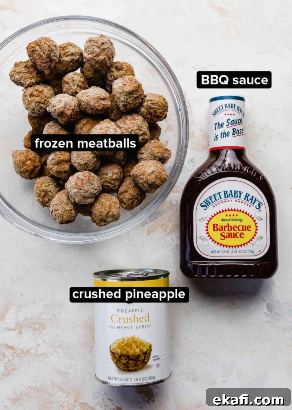Sticky Pineapple BBQ Meatballs 3 The three simple ingredients for BBQ Pineapple Meatballs: a bag of frozen meatballs, a bottle of Sweet Baby Ray's BBQ sauce, and a can of crushed pineapple, arranged on a clean white background.