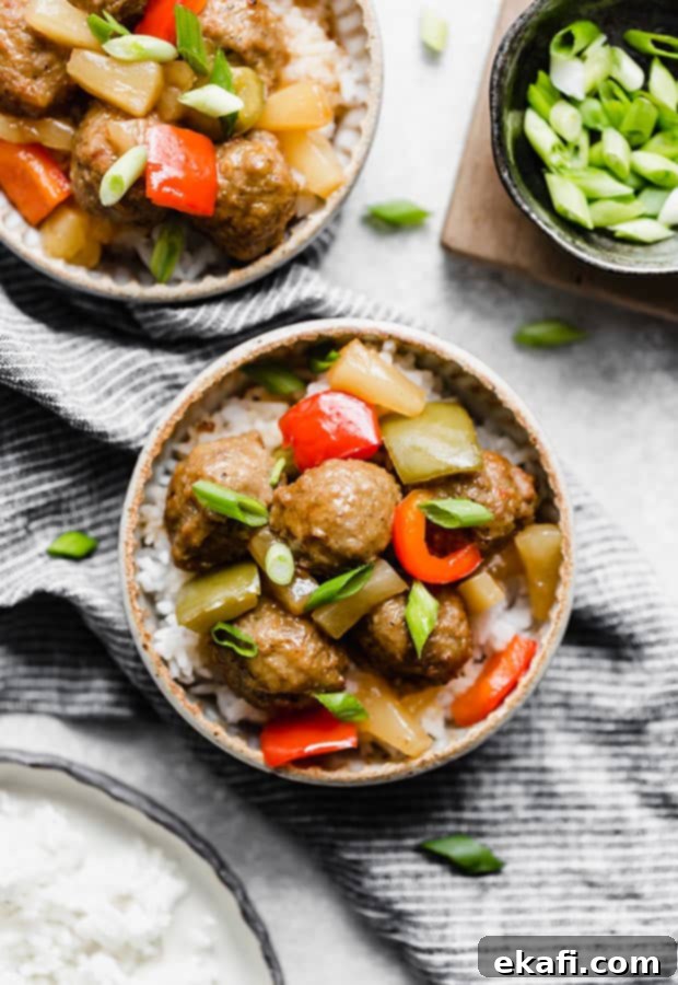Tangy Sweet Slow Cooker Meatballs 2 A bowl of Sweet and Sour Meatballs Recipe topped with chopped green onions.