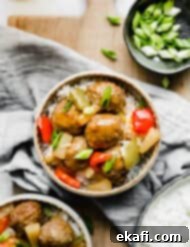 Tangy Sweet Slow Cooker Meatballs 9 A bowl of sweet and sour meatballs topped with green onions.