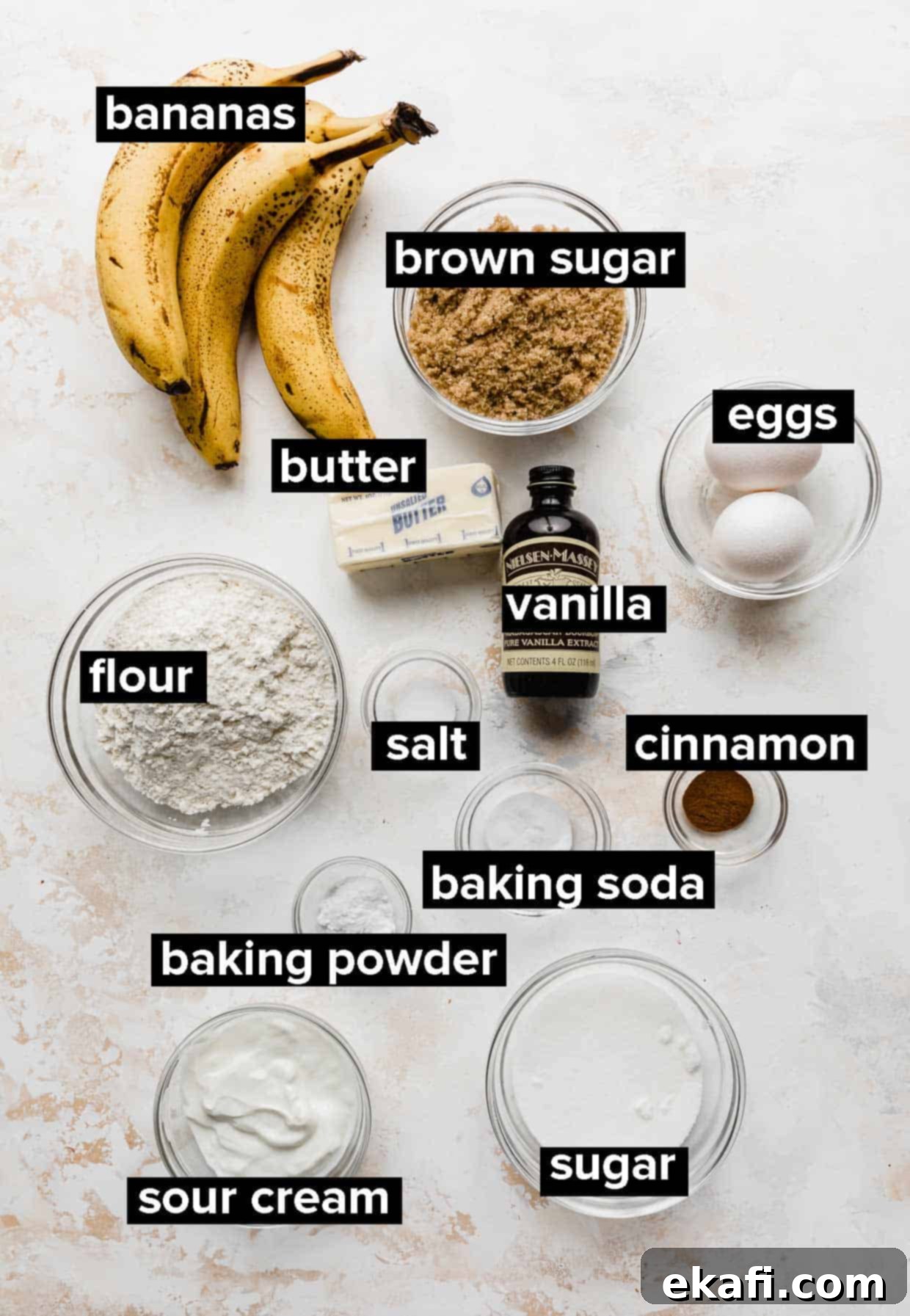 Irresistible Cinnamon Swirl Banana Bread 3 Ingredients used to make moist banana bread spread out on a cream and white textured background.