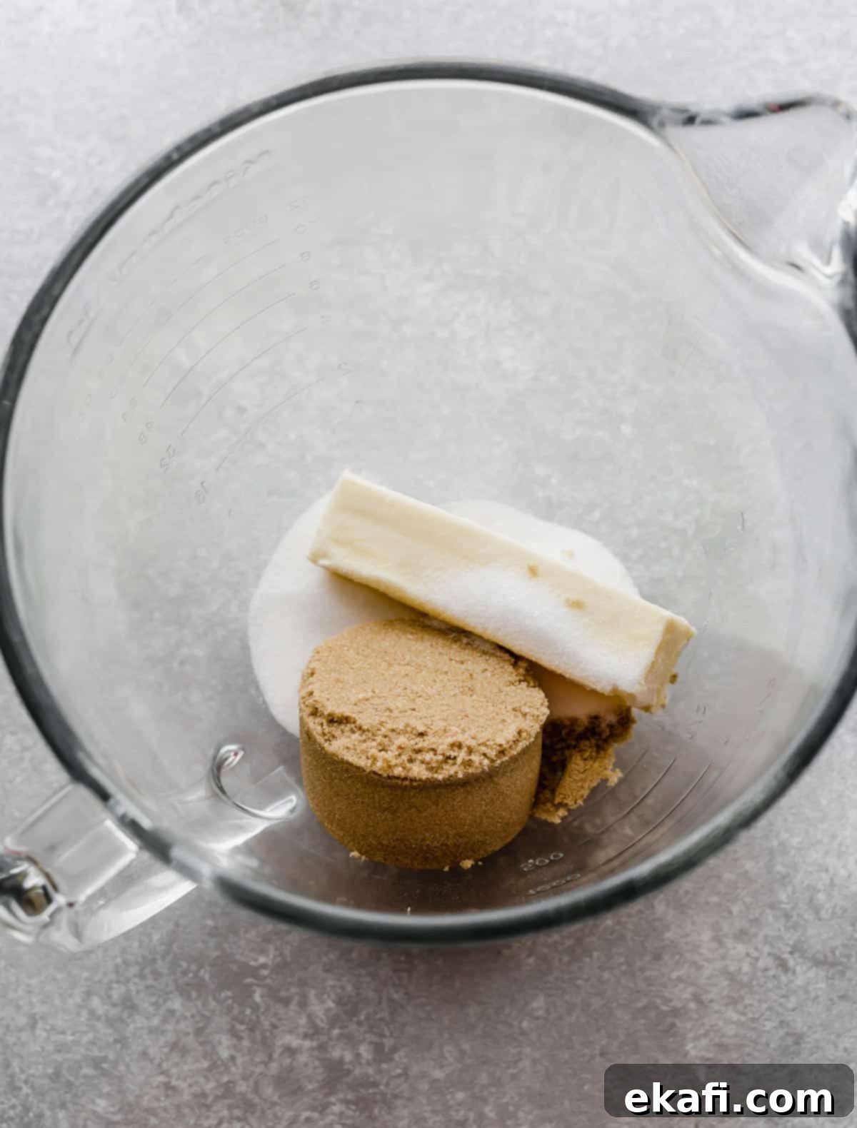 Irresistible Cinnamon Swirl Banana Bread 5 A glass bowl with a cube of butter, brown sugar, and sugar in it.