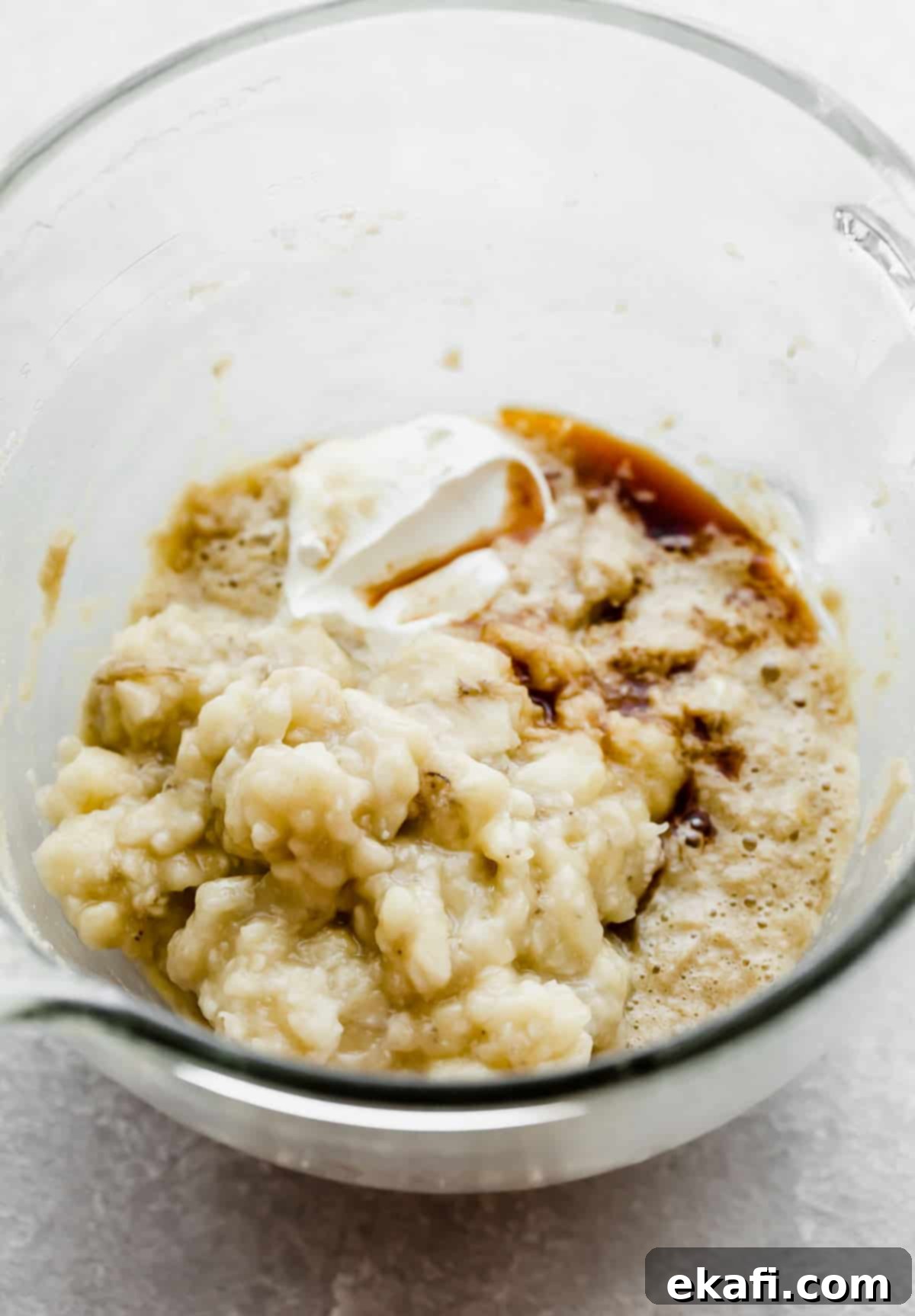 Irresistible Cinnamon Swirl Banana Bread 6 Mashed bananas, sour cream, and other Banana Bread Recipe ingredients in a glass mixing bowl.