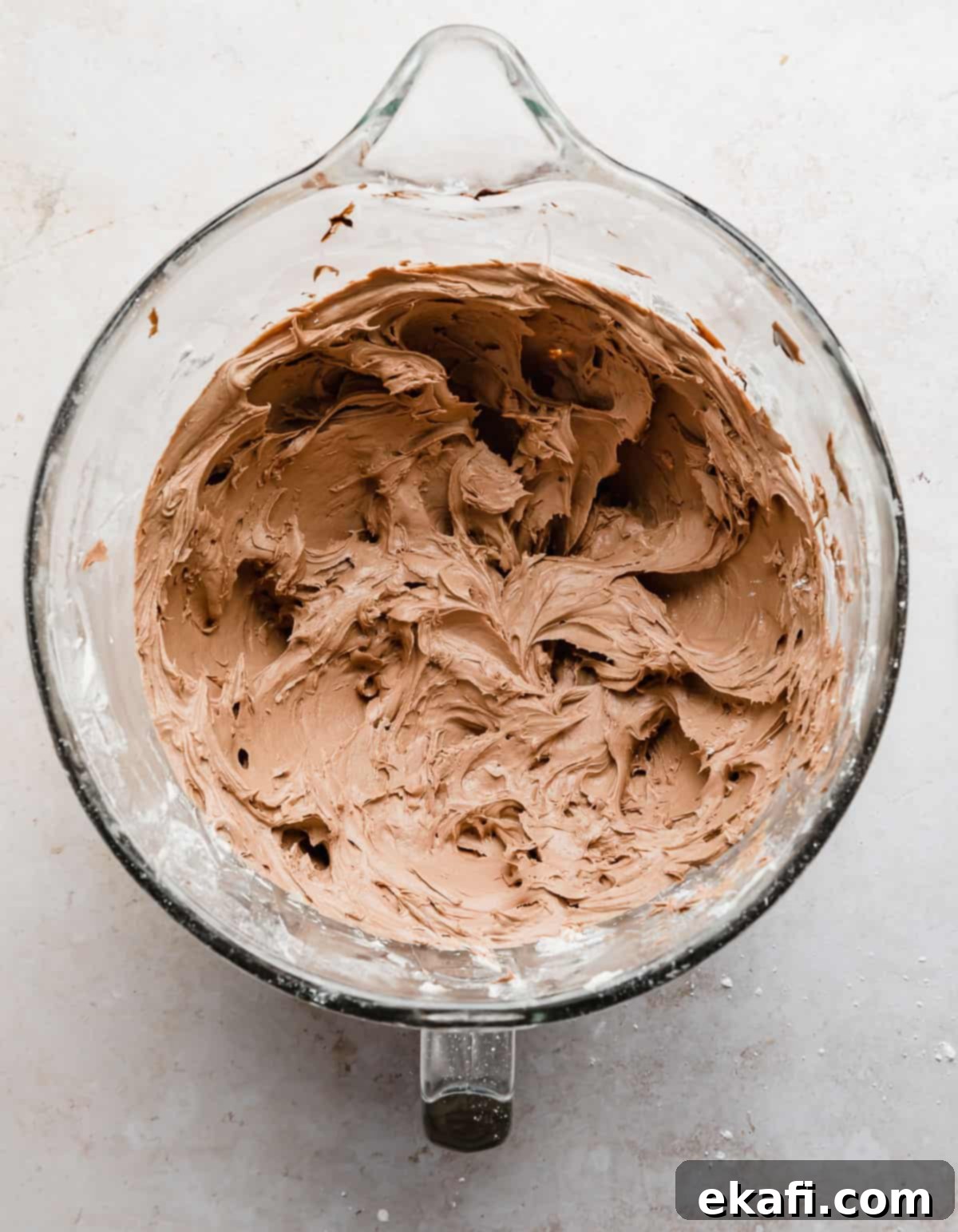 Decadent Chocolate Buttercream 11 Final Chocolate Buttercream Frosting made with Melted Chocolate, ready in a glass bowl on a pristine white background.