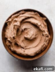 Decadent Chocolate Buttercream 15 Chocolate Buttercream Frosting Recipe made with melted chocolate in a brown bowl, ready to be served.