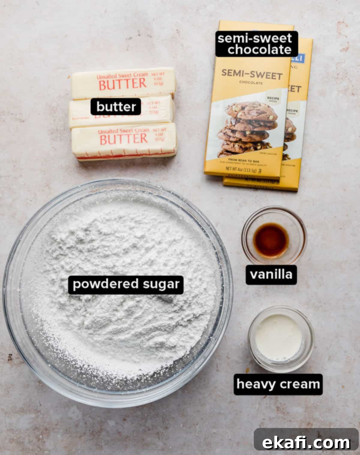 Decadent Chocolate Buttercream 3 A flat lay image displaying all the ingredients needed to make chocolate buttercream frosting, including butter, powdered sugar, vanilla, and chocolate.