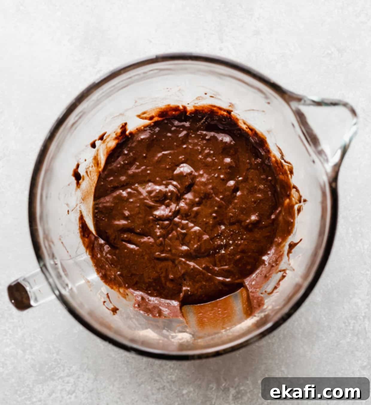 Irresistibly Rich Chocolate Cupcakes 6 Chocolate cupcake batter in a glass bowl on a light gray background.