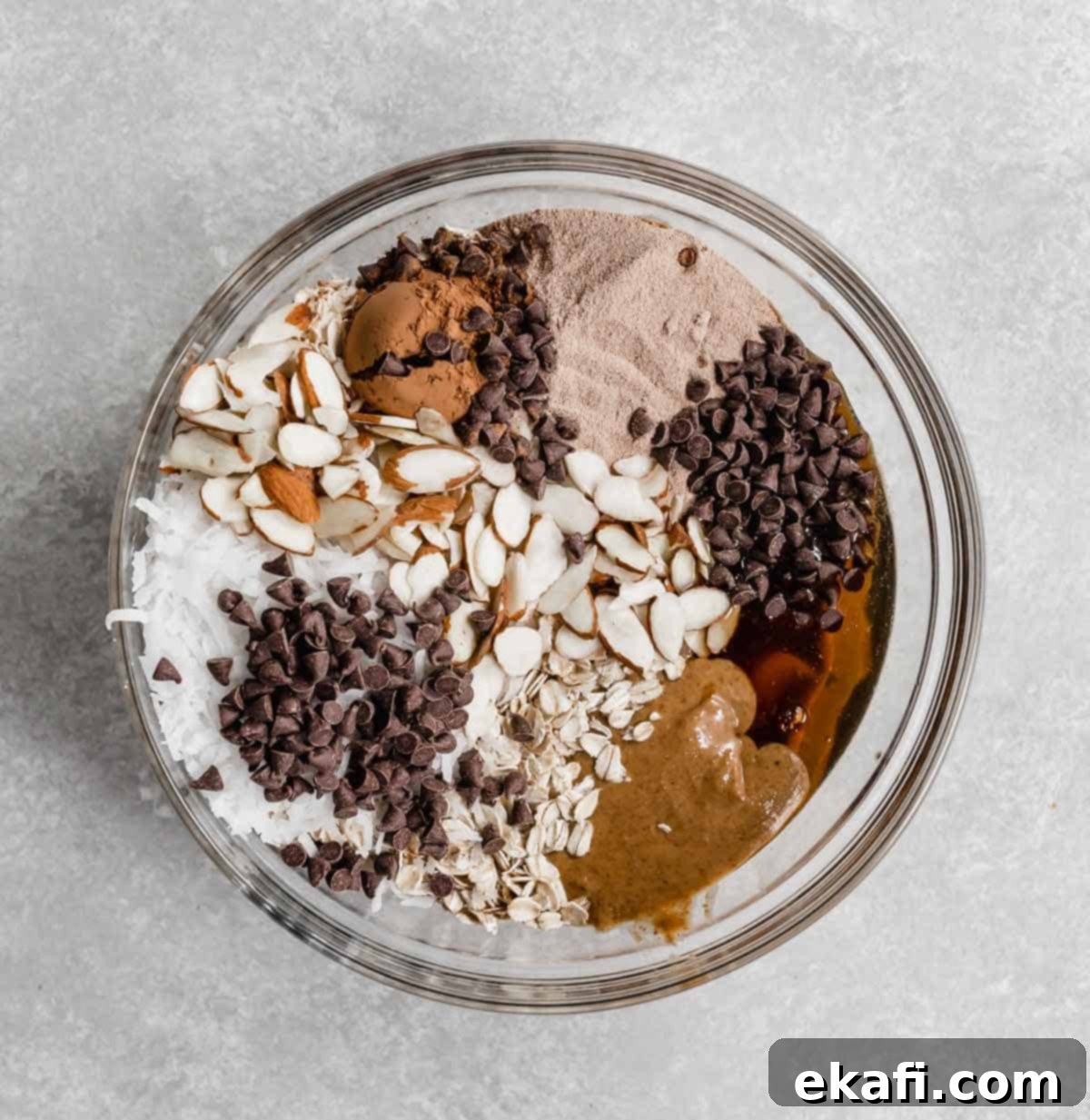 Μπάλες Πρωτεΐνης με Αμύγδαλο Joy 4 Almond Joy Protein Ball ingredients in a glass bowl on a light gray background.