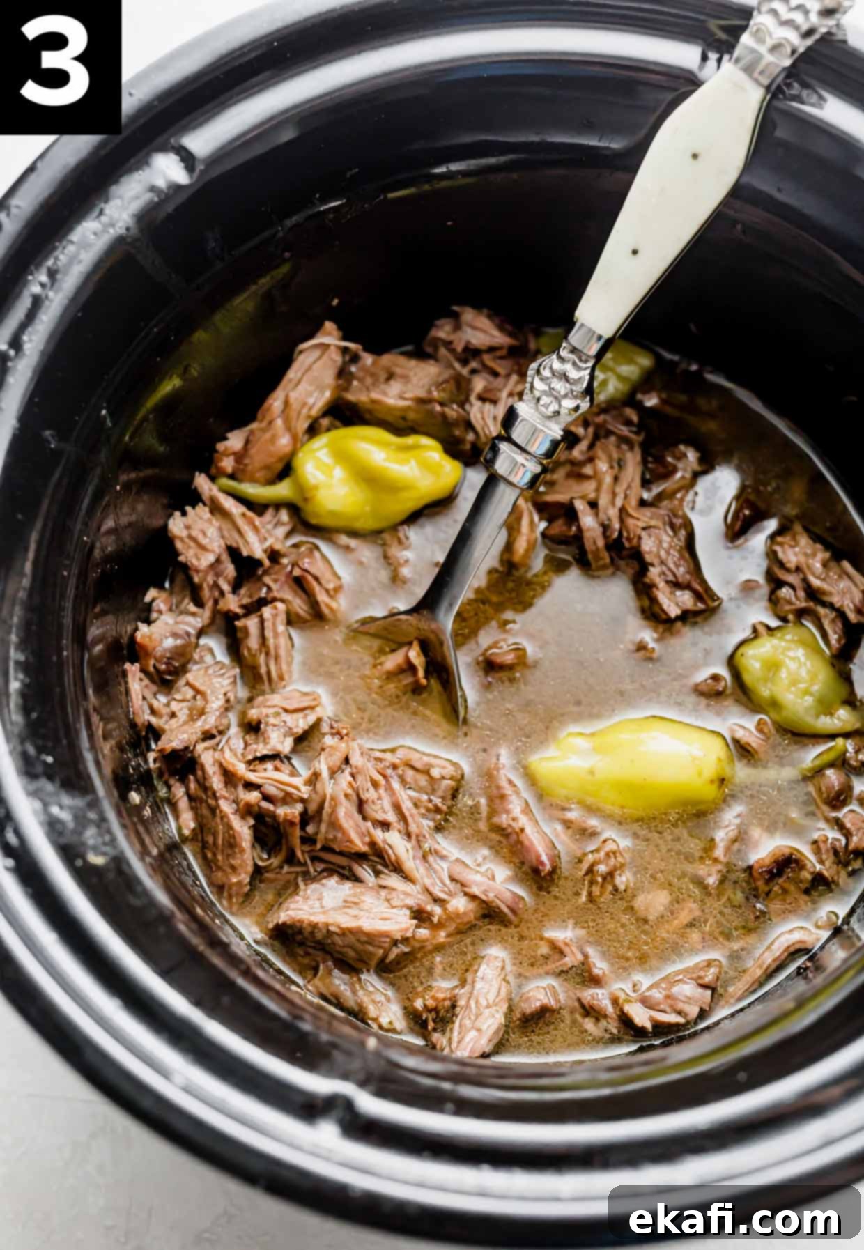 Southern Comfort Mississippi Pot Roast 5 Crock pot Mississippi Pot Roast in a black slow cooker with pepperoncini peppers amongst the meat.