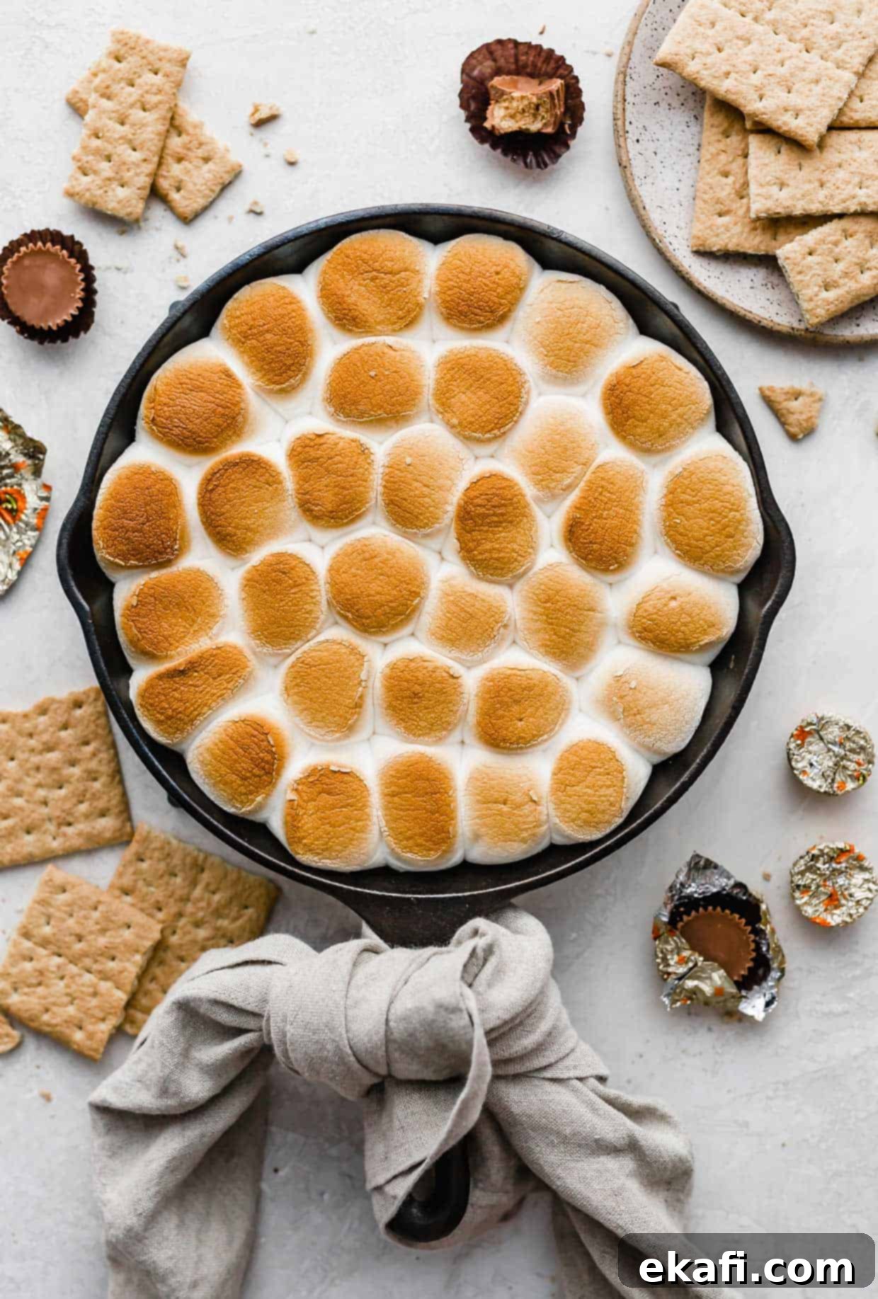 Ντιπ Σμόρες Ρήσης 6 Ένα τηγάνι Reese's S'mores Dip ψημένο στην τελειότητα, τοποθετημένο σε ανοιχτό γκρι φόντο.